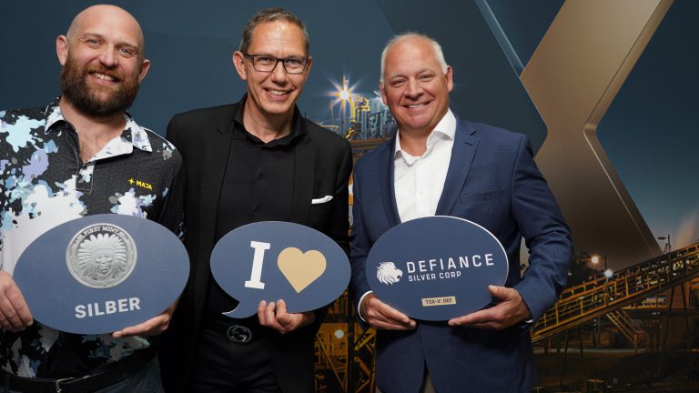 Three people holding signs "I Love", “Silver” and “Defiance Silver Corp.”